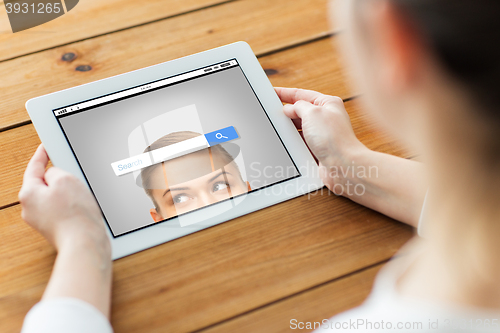 Image of close up of woman with tablet pc on wooden table