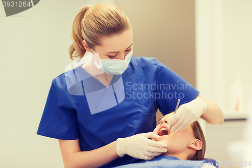 Image of female dentist checking patient girl teeth