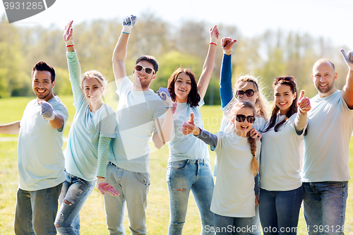 Image of group of volunteers showing thumbs up in park