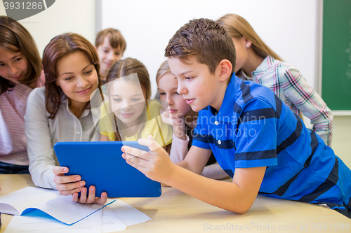 Image of group of kids with teacher and tablet pc at school