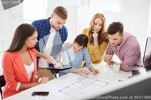 Image of creative team with blueprint working at office