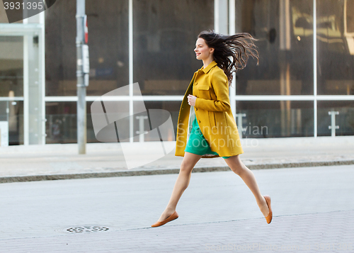 Image of happy young woman or teenage girl on city street