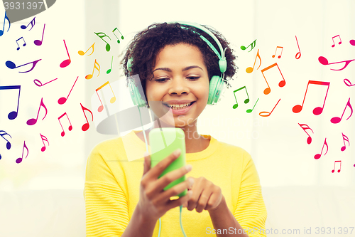Image of happy african woman with smartphone and headphones