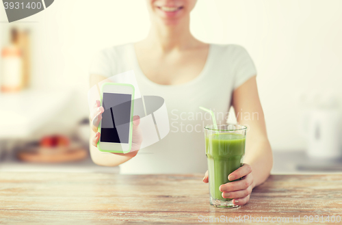 Image of close up of woman with smartphone and green juice