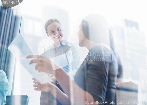 Image of smiling businesswomen meeting in office