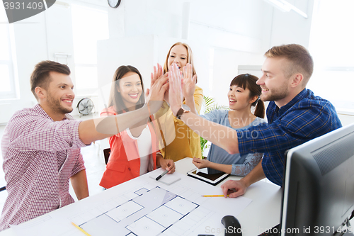 Image of creative team making high five at office