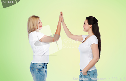 Image of group of happy different women in white t-shirts