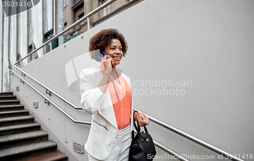 Image of happy african businesswoman calling on smartphone