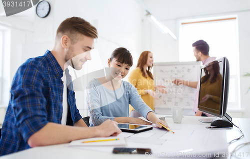 Image of creative team with blueprint at office
