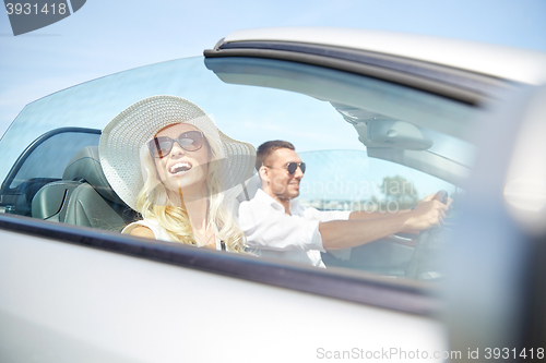 Image of happy man and woman driving in cabriolet car