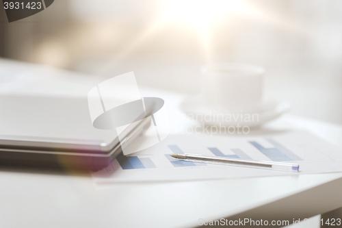 Image of close up of laptop computer, charts and coffee