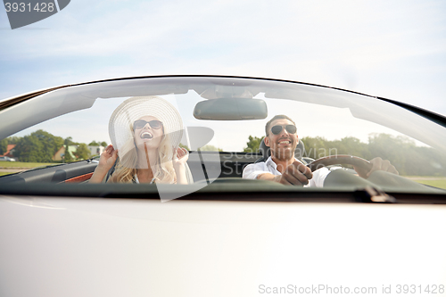 Image of happy man and woman driving in cabriolet car