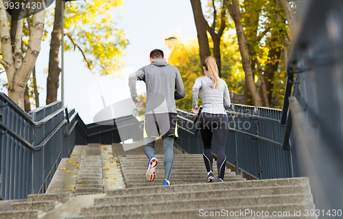 Image of couple running upstairs in city park