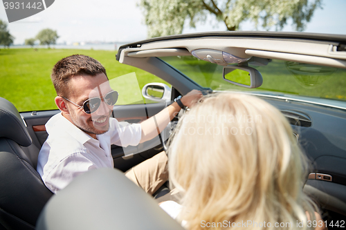 Image of happy man and woman driving in cabriolet car