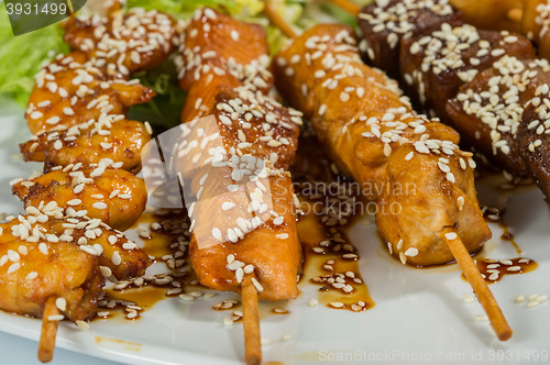 Image of Grilled juicy skewered shashlik on a plate, sesame