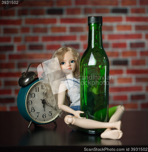 Image of doll with a bottle. the concept of alcoholism