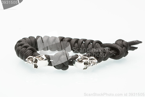 Image of Black braided bracelet with skulls on white background