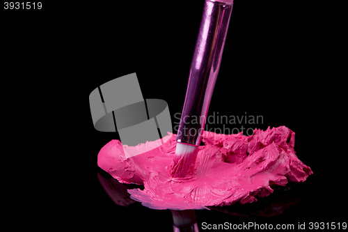 Image of lipstick with a brush make-up on black 