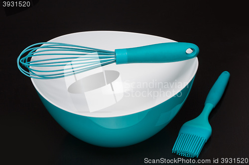 Image of Green silicone pastry brush and soup plate isolated on black