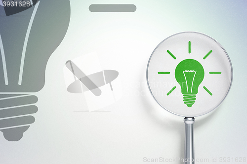 Image of Finance concept:  Light Bulb with optical glass on digital background