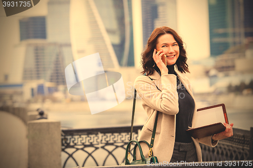Image of smiling middle-aged woman using a smartphone