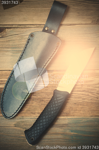 Image of shiny hunting knife and leather scabbard