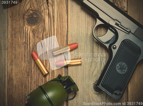 Image of handgun with cartridges and grenade