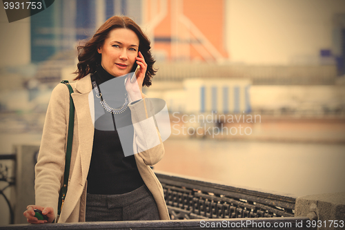 Image of middle-aged woman talking on the phone and smiling