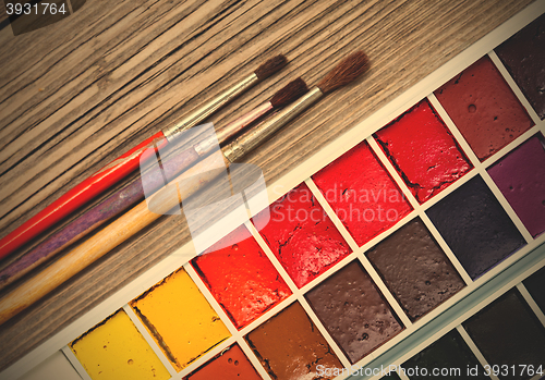 Image of aquarelle paint-box and three brushes