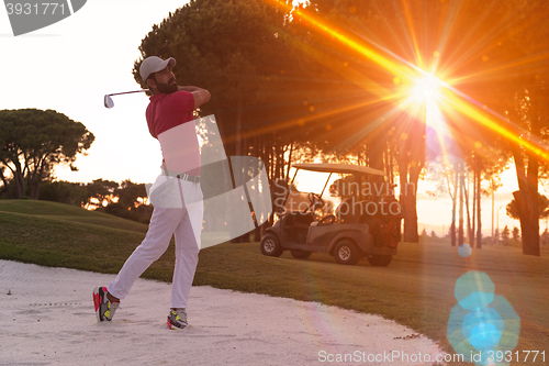 Image of golfer hitting a sand bunker shot on sunset