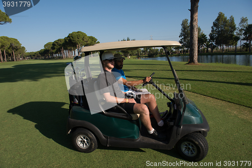 Image of golf players driving cart at course