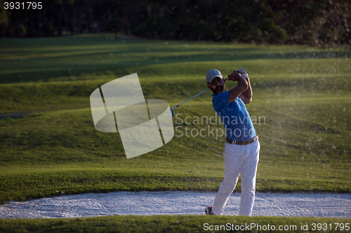 Image of golfer hitting a sand bunker shot on sunset