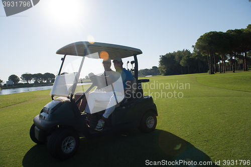 Image of golf players driving cart at course