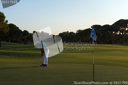 Image of golfer hitting ball to hole