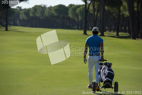 Image of golf player walking with wheel bag