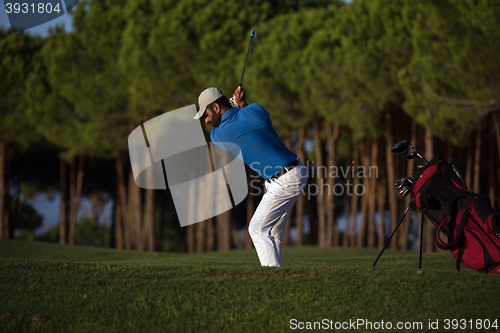 Image of golfer hitting a sand bunker shot on sunset