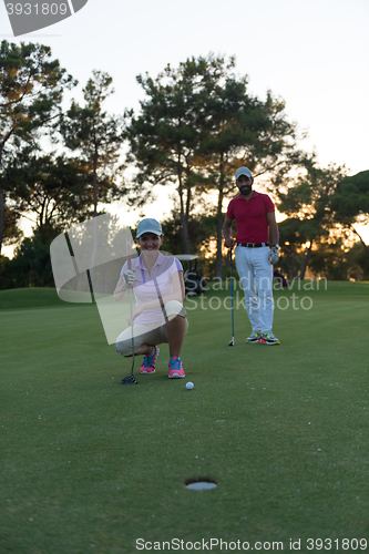 Image of couple on golf course at sunset