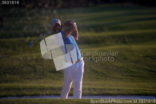 Image of golfer hitting a sand bunker shot on sunset