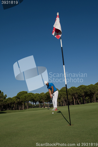 Image of golf player hitting shot at sunny day