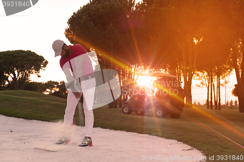 Image of golfer hitting a sand bunker shot on sunset