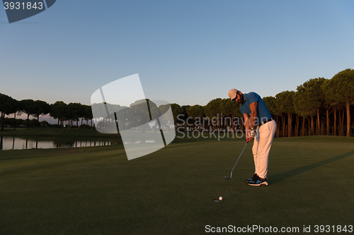 Image of golfer  hitting shot at golf course