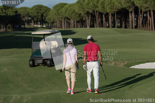 Image of couple walking on golf course