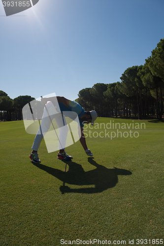 Image of golf player placing ball on tee