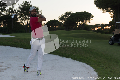 Image of golfer hitting a sand bunker shot on sunset