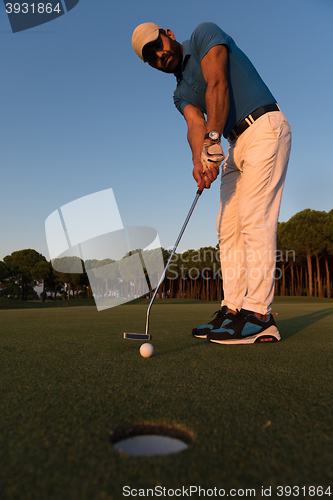 Image of golfer  hitting shot at golf course