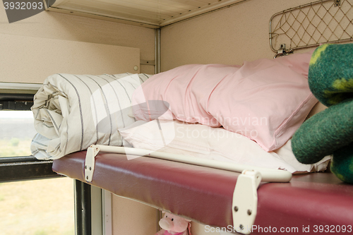 Image of The top shelf in the second-class compartment of the train wagon with bedding