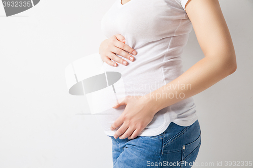 Image of Unrecognizable pregnant woman embracing belly