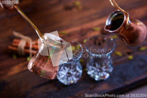Image of To pour arabic coffee in cups on wooden background.