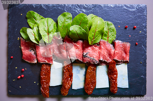 Image of slices ham with cheese and leaves of beets