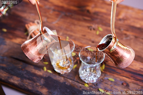 Image of To pour arabic coffee in cups on wooden background.